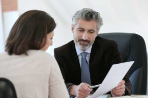 Parent reviewing custody documents with a lawyer at a conference table.