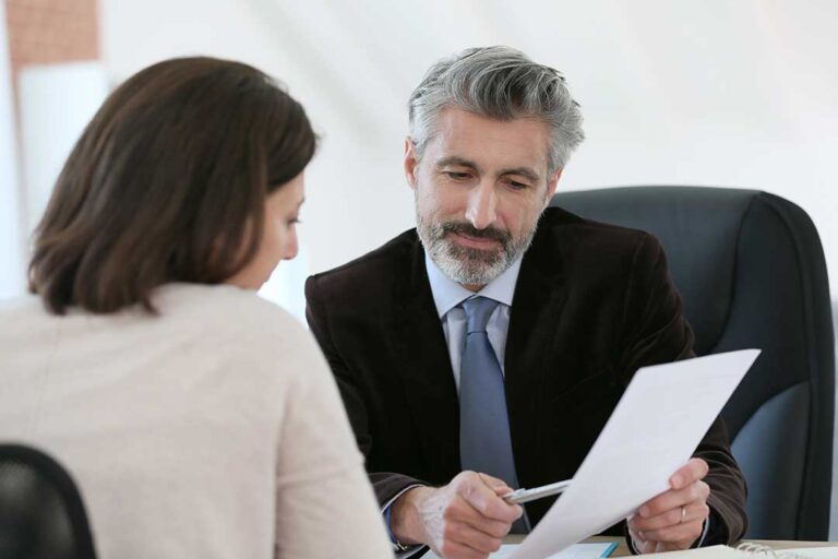 Parent reviewing custody documents with a lawyer at a conference table.